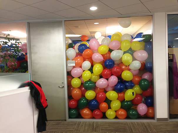 Office conference room filled with balloons