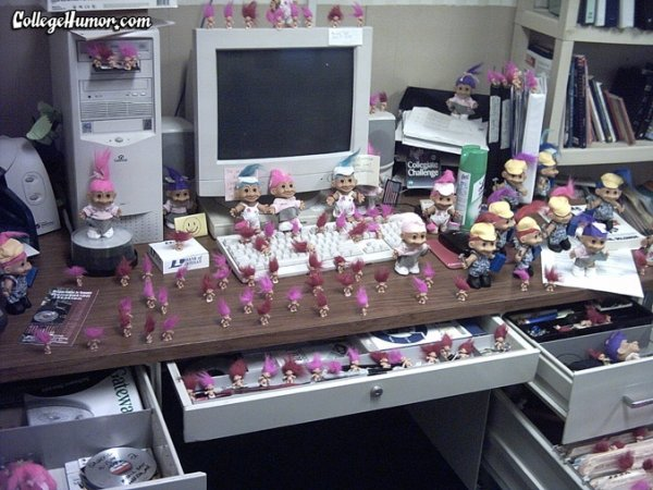Office desk full of pink troll dolls