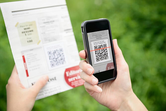 Person scanning QR code with a scanning mobile app