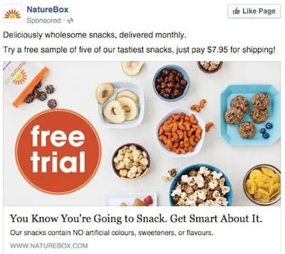 A close-up photo of a NatureBox advertisement for healthy snacks. The advertisement features a variety of snacks on a wooden table, including dried fruit, nuts, and granola bars.