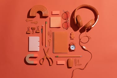 Headphones, sunglasses, notebook, scissors, pen, eraser, and other desk tools