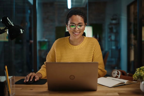 A woman looks into her computer to read the State of Consumer Trends Report Coming August 2022