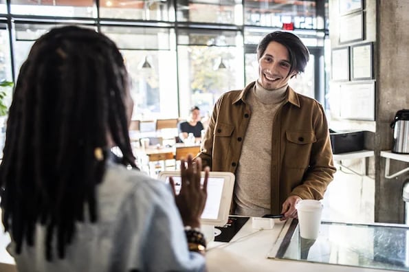 man signing up for customer loyalty program at coffee shop