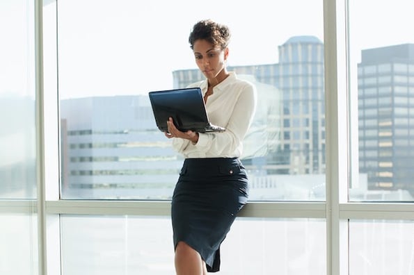 woman standing holding a laptop and renewing an SSL certificate for her website