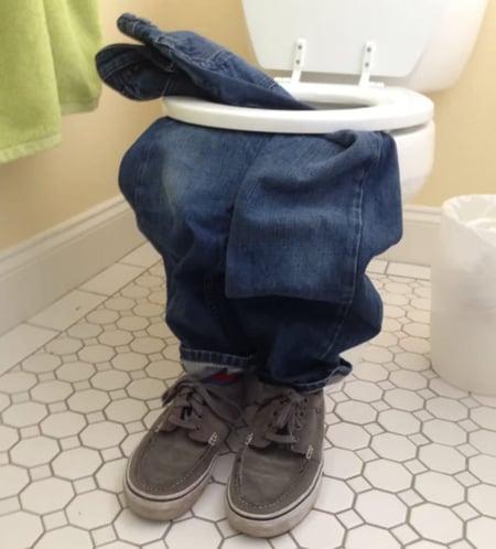 Office prank with empty pants and shoes in bathroom stall