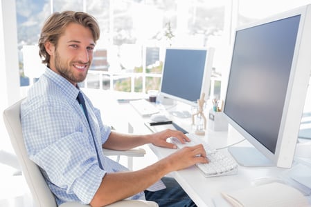 Smiling designer working at his desk in modern office