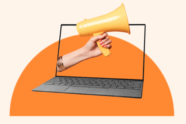 Hand holding megaphone with display screen on laptop symbolizing call-to-action