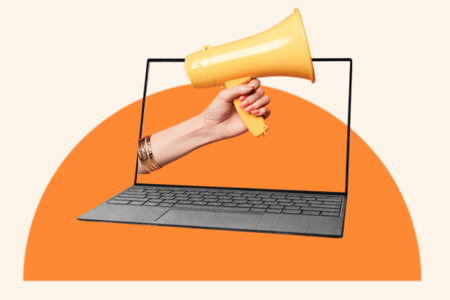 Laptop with its screen displaying a hand holding a megaphone symbolizes a call-to-action