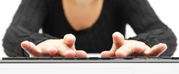 person typing on keyboard researching the best business writers online