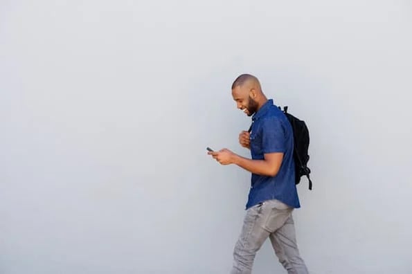 man walking while looking at smartphone and reading about buyer's remorse