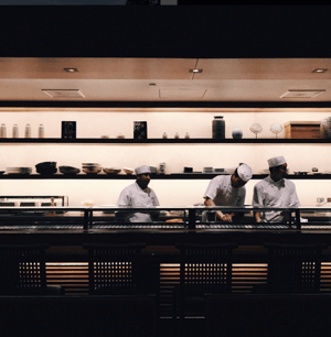 Candid shot of three chefs cooking, taken with phone camera