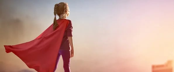 child with superhero cape boosting confidence