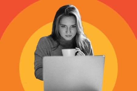 person looking at css gradients on their computer with a coffee mug in hand 