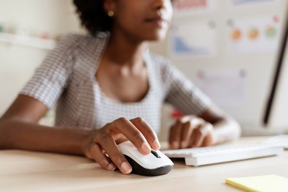 Woman clicking CTA copy at her desk.