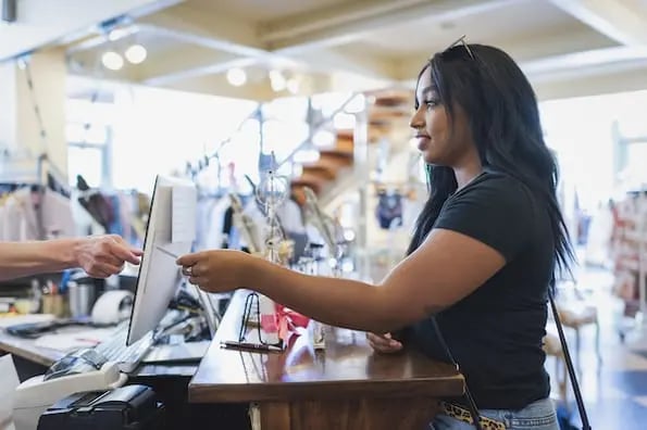 woman paying at counter and using customer loyalty punch card