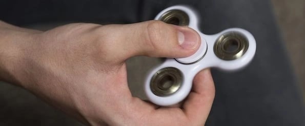 distractions that make you more productive: image shows hand holding a fidget spinner