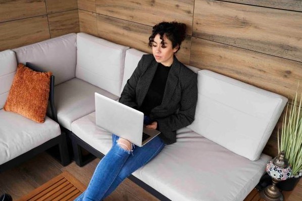 Woman creates an email for lead generation while sitting on a couch