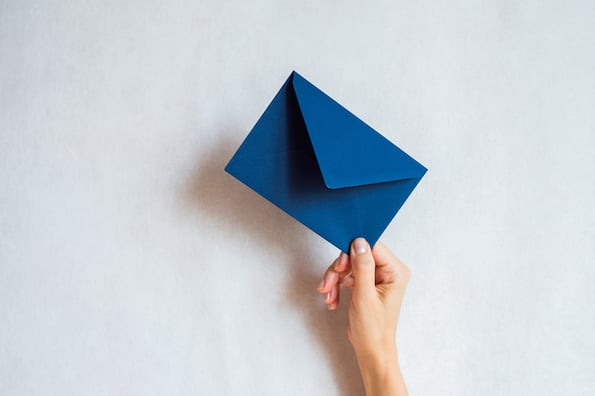 hand holding a blue envelope