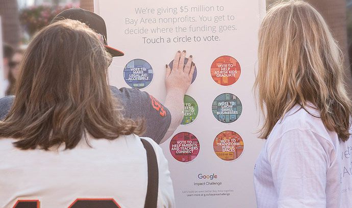 Women touching an interactive poster by Google, as part of the company's experiential marketing campaign, Building a Better Bay Area