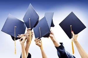 graduates raising caps in air