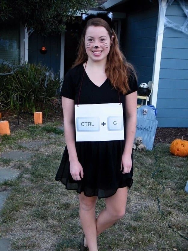 Girl in copycat Halloween costume with black cat makeup and CNTRL + C labeled necklace