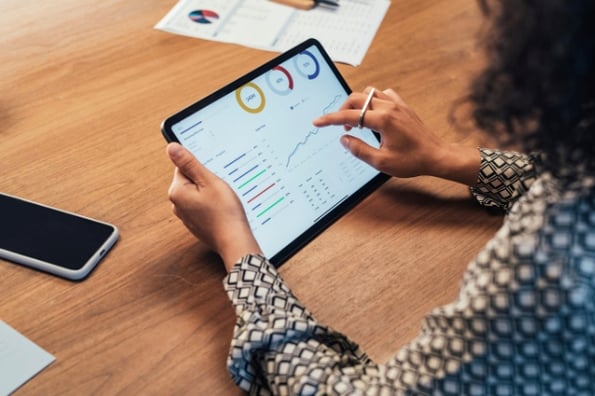 Woman learning how to calculate website traffic with tablet