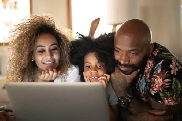 A family watches a video together on a laptop; video consumption