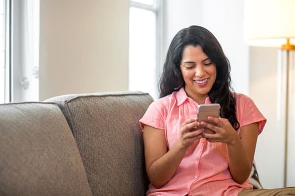 bir kadın, bir markanın SMS pazarlama kampanyasından bir metin alır.