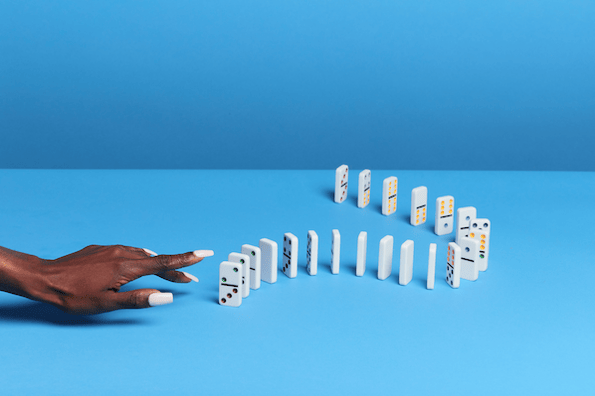 A marketing leader knocks over dominoes that symbolize mounting marketing challenges