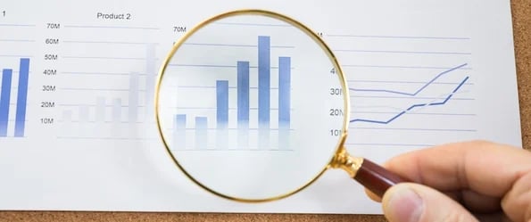 common marketing reporting questions: image shows magnifying glass over stats graph