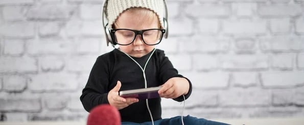 Most Interesting Podcast Episodes About Productivity: image shows baby with headphones listening to podcast