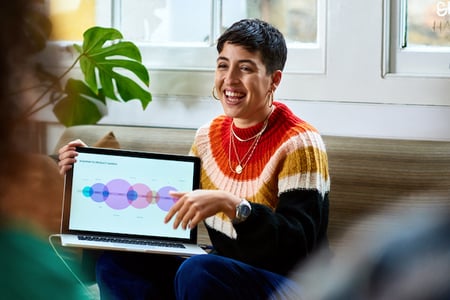person using a wordpress project management plugin on a laptop and smiling