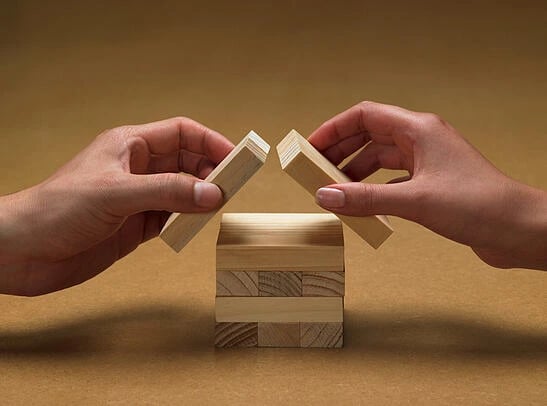 simple promotion framework to support content strategy: image shows two hands stacking wooden blocks