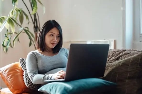 woman sitting on couch reading reddit stats