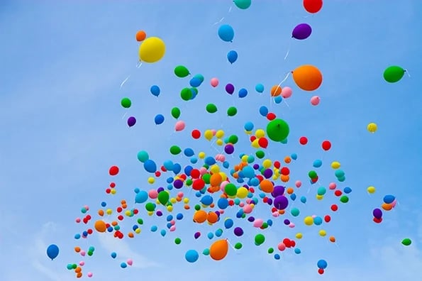 blue sky full of multi-colored balloons