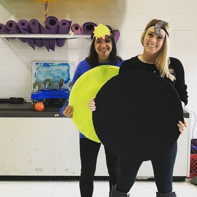 Two girls dressed in solar eclipse costume at an office
