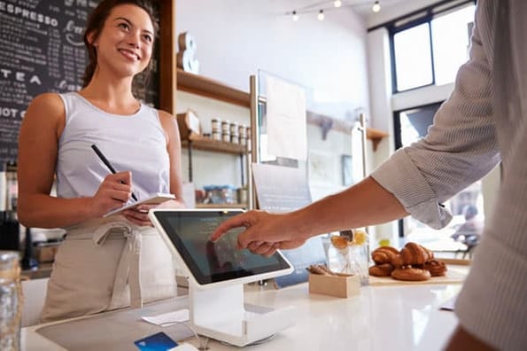 A person pays for food with an ipad at a cafe with the help of Square software