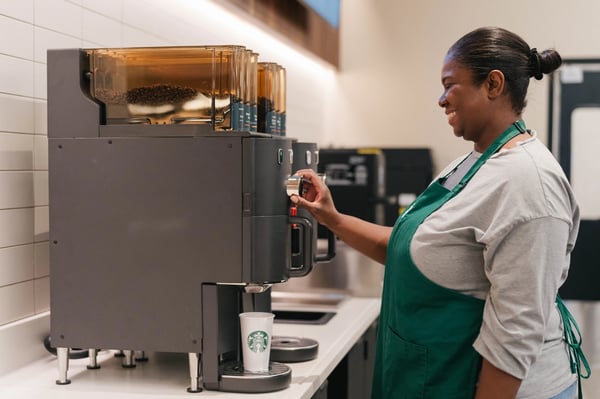 A woman brewing coffee in Starbucks. 