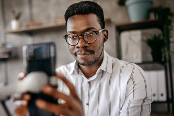 A man records a TikTok resume on his phone. 