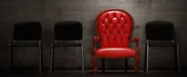 how to stand out: image shows red chair in a row of black chairs