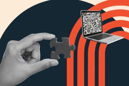web design vs graphic design: image shows a hand holding a puzzle piece holding it up to a laptop with gears on the screen 