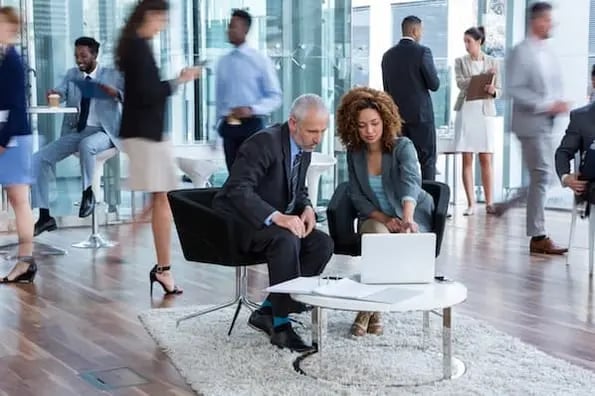 Two sales representatives learning about sales in an office setting