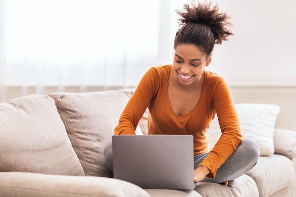 woman sitting on a couch using a computer to migrate a WordPress website with WordPress Duplicator