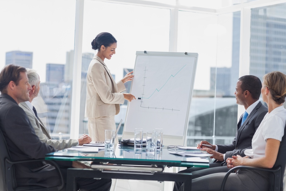 Businesswoman pointing at a growing chart during a meeting in the meeting room.jpeg