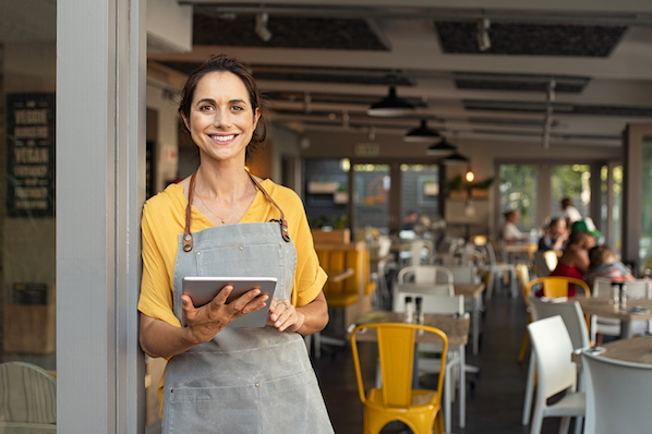 Small business owner pictured with a tablet viewing a new WordPress theme for her small business