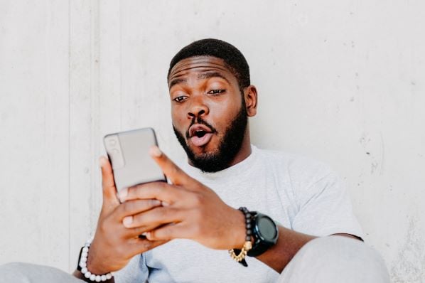 Man looks at viral social media platforms on his cell phone