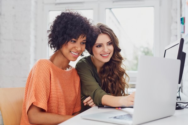 two women using a laptop to find a WordPress page builder for their WordPress website