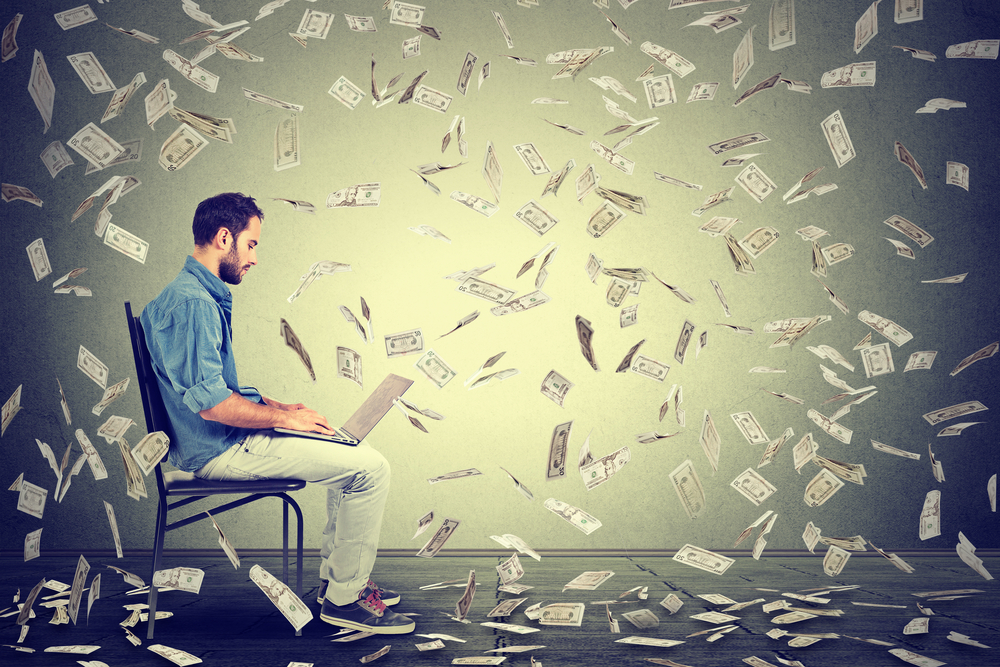 Money raining down on an entrepreneur on computer