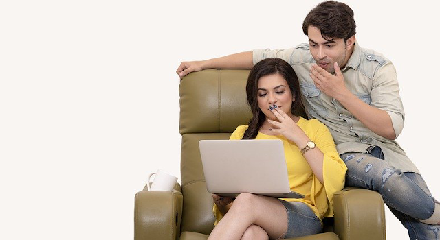 A couple looking excitedly at a computer