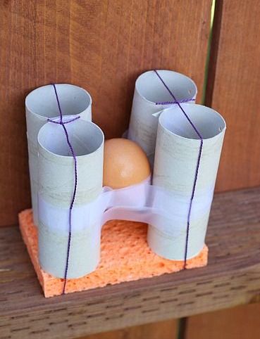 Egg taped to four toilet paper rolls and a sponge for an egg drop challenge